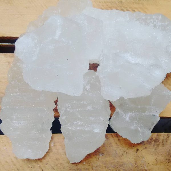 La imagen muestra al menos 5 piedras de alumbre sobre tablas de madera